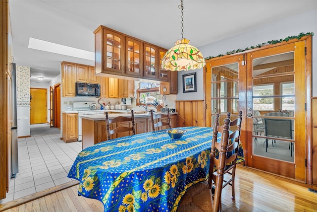 dining room with a healthy amount of sunlight, light wood-style floors, and french doors