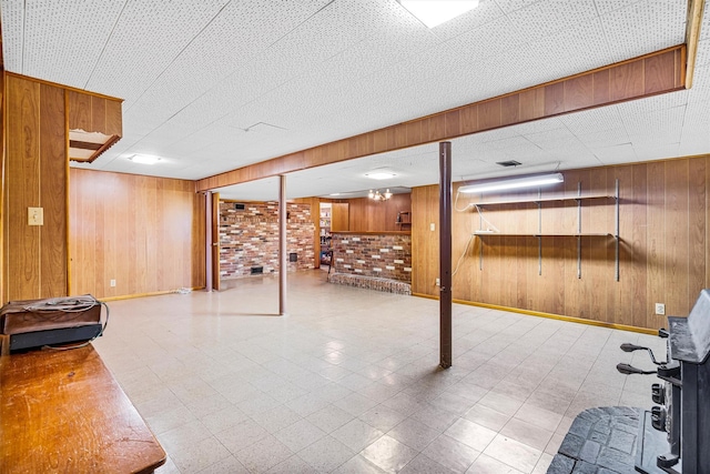 finished basement with baseboards, wooden walls, and tile patterned floors