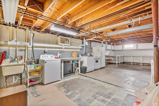 basement with freestanding refrigerator, independent washer and dryer, and a sink