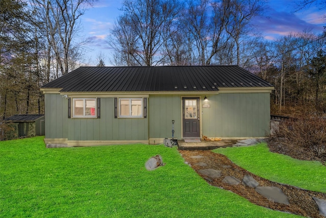 view of front of property featuring a front lawn and metal roof