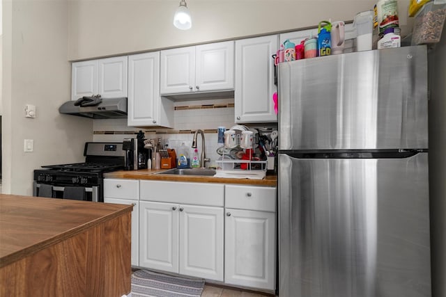 kitchen with stainless steel appliances, tasteful backsplash, exhaust hood, and white cabinetry