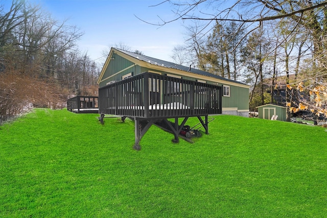 rear view of property with an outdoor structure, a storage unit, a lawn, and metal roof