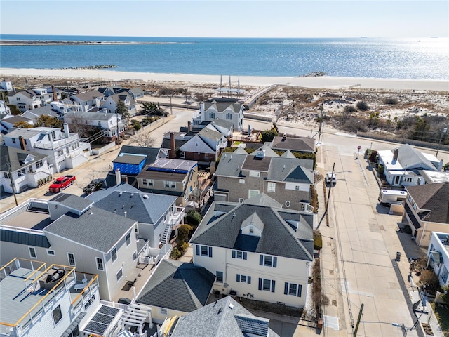 birds eye view of property featuring a water view, a residential view, and a beach view