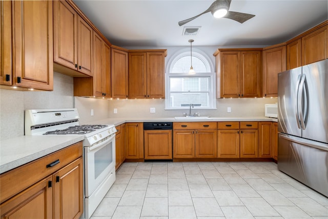 kitchen featuring white appliances, visible vents, brown cabinets, light countertops, and a sink