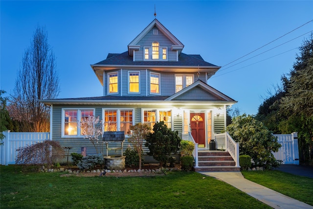 view of front of house with fence and a front lawn