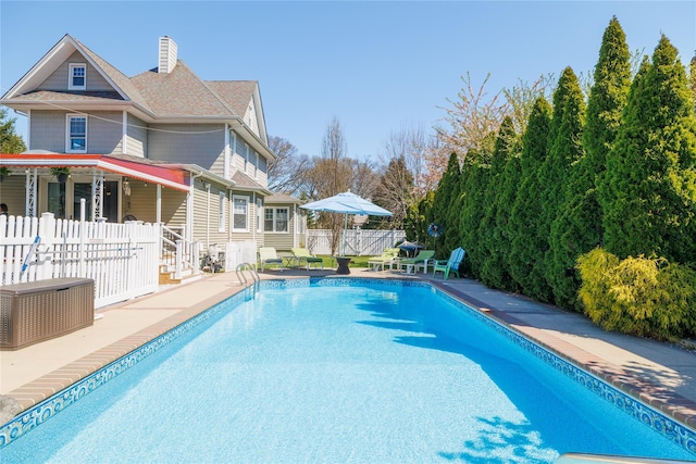 view of swimming pool featuring a patio area, fence, and a fenced in pool