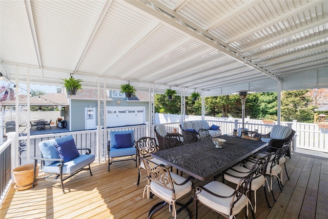 wooden deck with an outbuilding, outdoor dining area, and fence