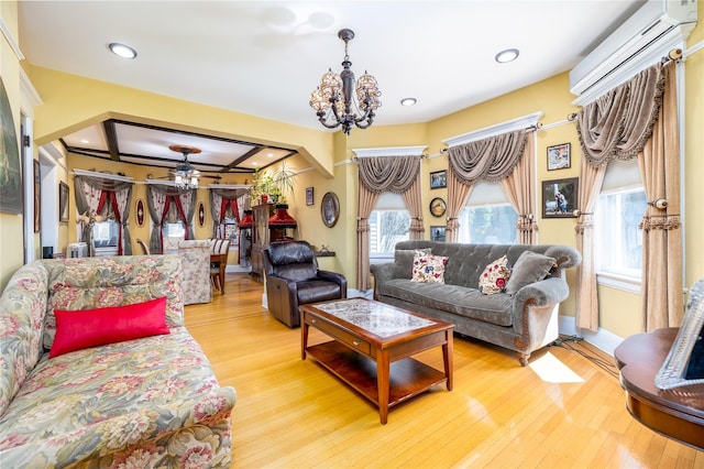 living area featuring baseboards, hardwood / wood-style flooring, a wall mounted AC, a chandelier, and recessed lighting