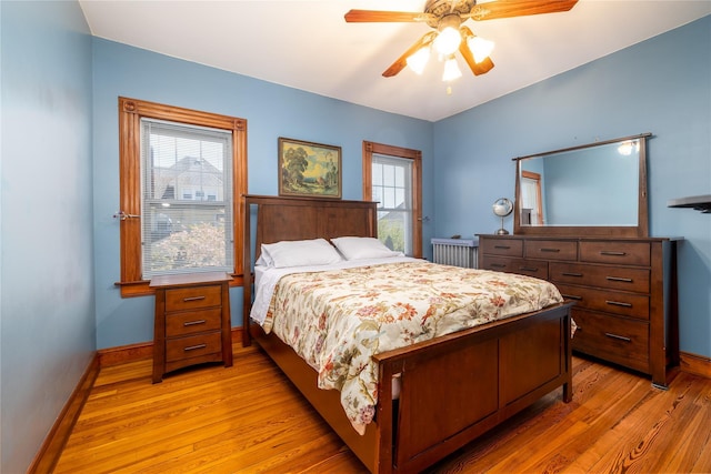 bedroom with baseboards, ceiling fan, and light wood finished floors