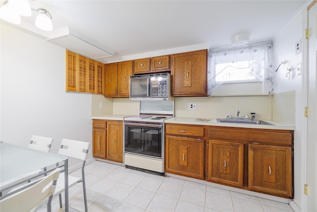 kitchen with white electric stove, light countertops, brown cabinetry, and a sink