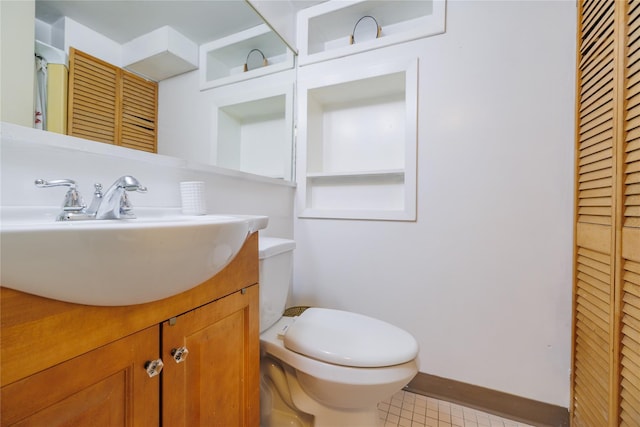 bathroom with baseboards, vanity, toilet, and tile patterned floors