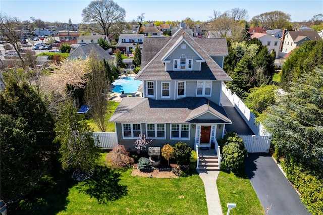 view of front of property with a front lawn, fence, and a residential view