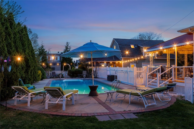 pool at dusk featuring a fenced in pool, a patio area, and fence