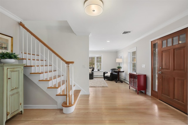 entryway featuring visible vents, light wood-style flooring, and ornamental molding