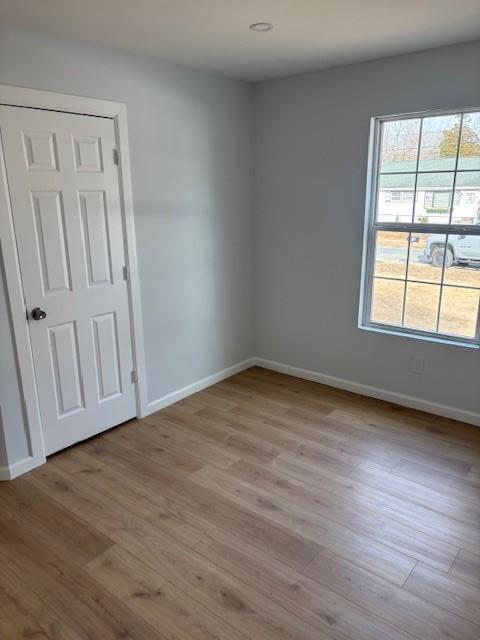 spare room featuring light wood-style floors and baseboards