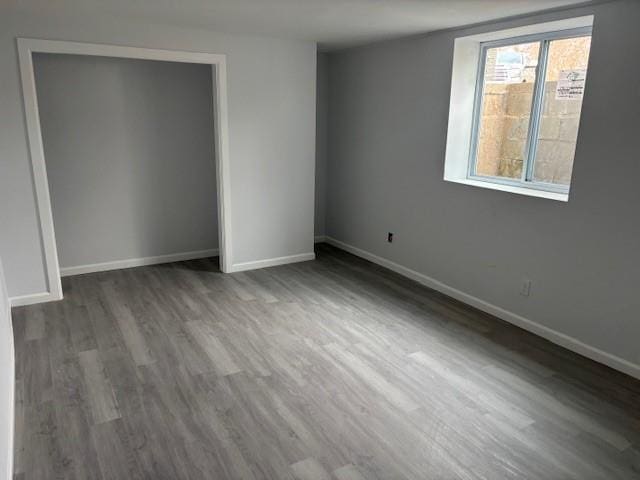 unfurnished bedroom featuring a closet, baseboards, and wood finished floors