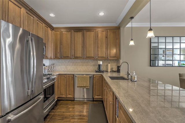 kitchen featuring brown cabinets, crown molding, appliances with stainless steel finishes, a sink, and light stone countertops