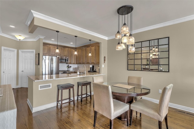 dining room with dark wood-style flooring, visible vents, crown molding, and baseboards