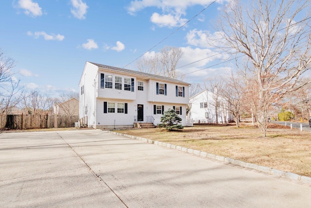 colonial-style house featuring a front yard