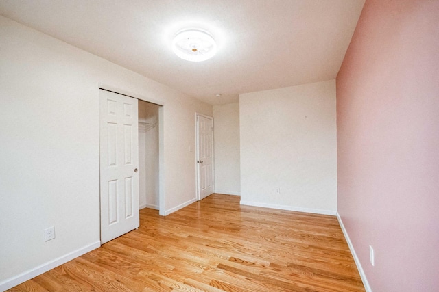 spare room featuring baseboards and light wood-style floors