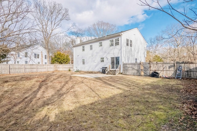 back of house featuring entry steps, a patio area, a fenced backyard, and a chimney