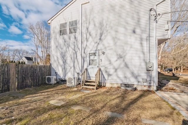 back of property with entry steps, ac unit, and fence