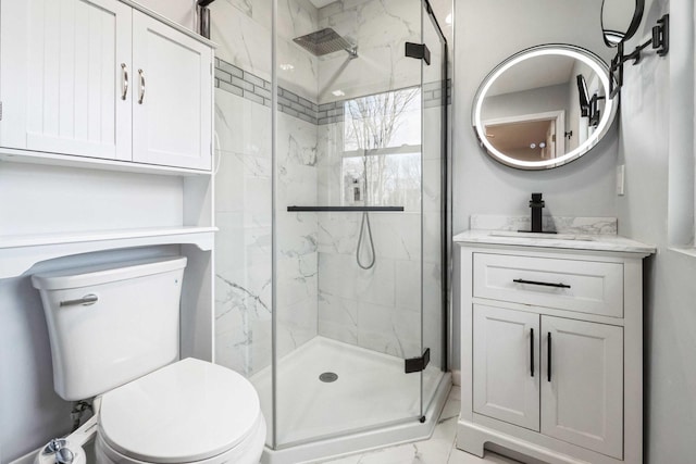 bathroom with marble finish floor, vanity, a marble finish shower, and toilet