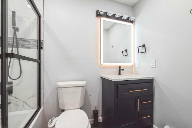 bathroom with shower / bath combination with glass door, vanity, toilet, and baseboards