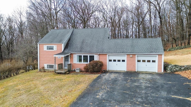 view of front of home featuring a garage, aphalt driveway, roof with shingles, a front lawn, and brick siding