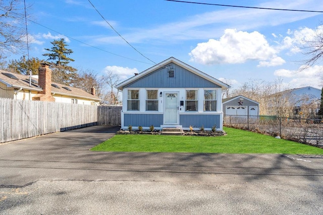 bungalow-style house featuring fence private yard, a front lawn, and entry steps