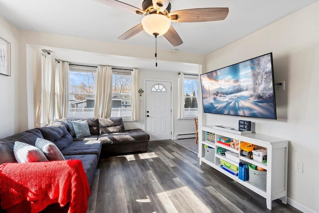 living area featuring a ceiling fan, baseboards, a baseboard heating unit, and wood finished floors