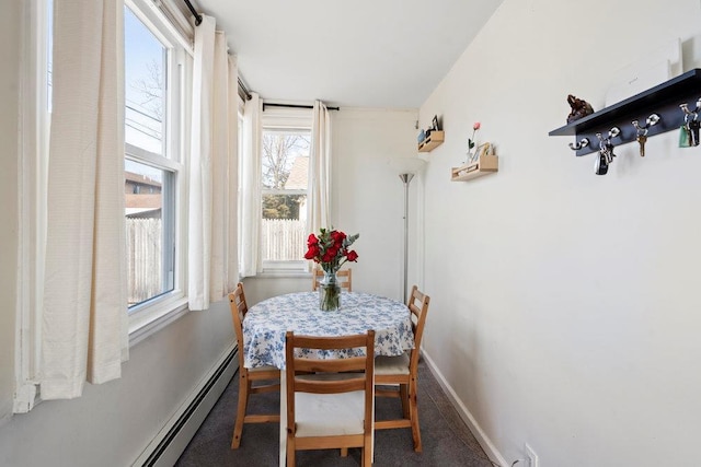 dining room with baseboard heating, carpet, and baseboards