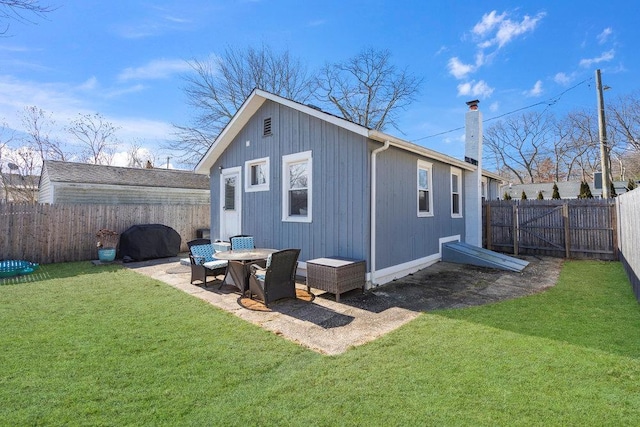 back of house with a patio area, a fenced backyard, a chimney, and a lawn