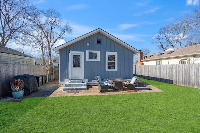 rear view of property with an outdoor fire pit, a fenced backyard, an outbuilding, and a yard