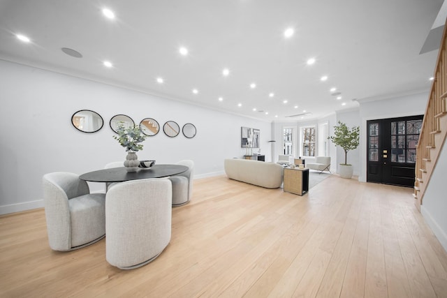 dining area with recessed lighting, light wood-style flooring, crown molding, and stairs