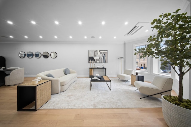 living room with baseboards, visible vents, recessed lighting, ornamental molding, and light wood-type flooring