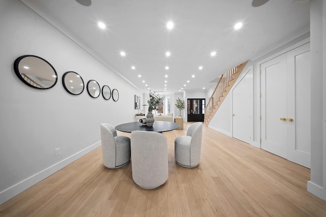 dining space featuring crown molding, baseboards, stairs, recessed lighting, and light wood-style floors