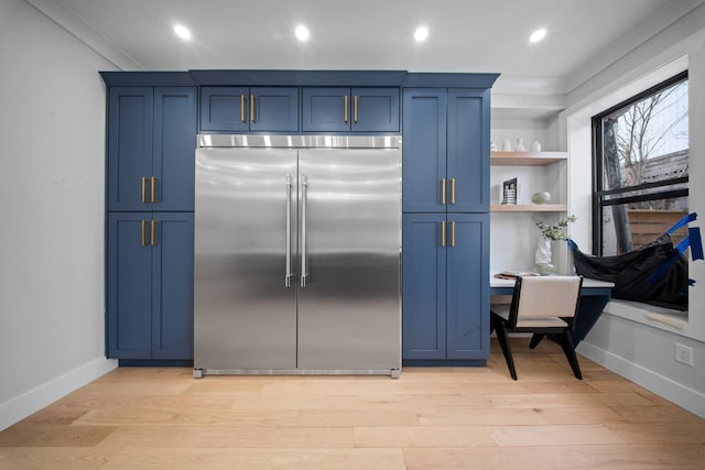 kitchen featuring light wood finished floors, open shelves, blue cabinetry, recessed lighting, and stainless steel built in refrigerator