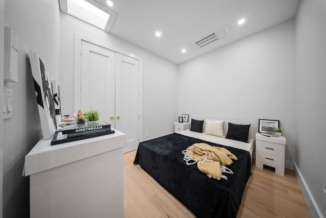 bedroom with visible vents, recessed lighting, a closet, light wood finished floors, and baseboards