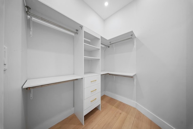 walk in closet with light wood-style flooring