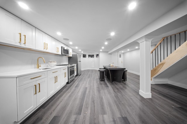 kitchen featuring white cabinetry, stainless steel appliances, dark wood-type flooring, and a sink