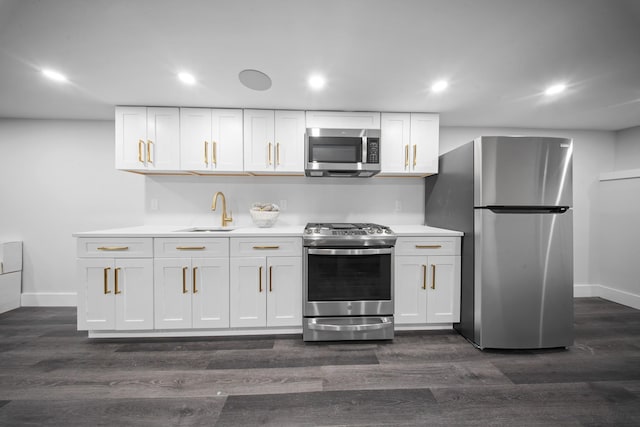 kitchen featuring appliances with stainless steel finishes, white cabinetry, light countertops, and a sink