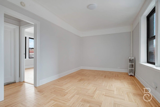 empty room featuring radiator heating unit and baseboards