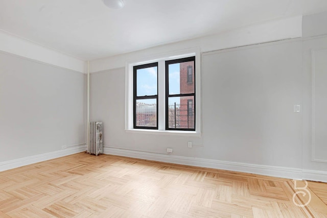 spare room featuring baseboards and radiator heating unit