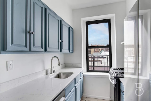37-16 83rd St Unit 4E, Jackson Heights, NY 11372 - kitchen featuring appliances with stainless steel finishes, light stone countertops, blue cabinets, and light tile patterned floors