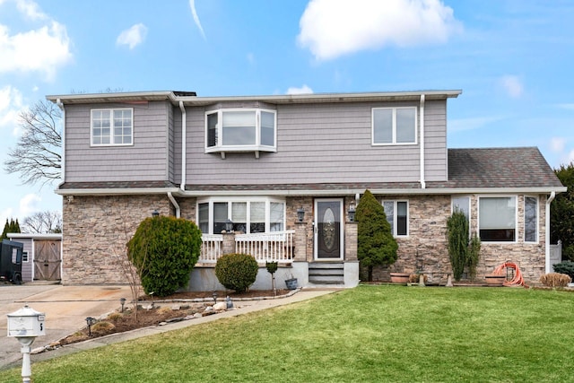 traditional-style house featuring driveway, stone siding, and a front lawn