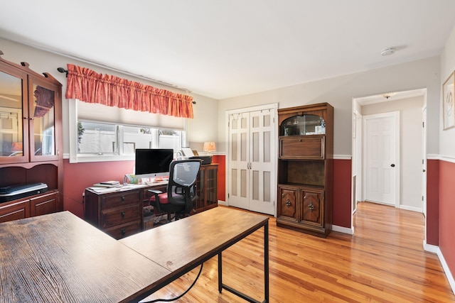 home office with light wood-type flooring and baseboards