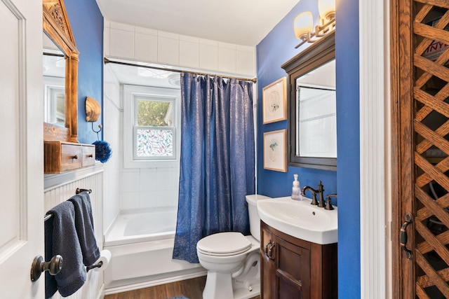 full bathroom with wood finished floors, shower / bath combo, vanity, and toilet