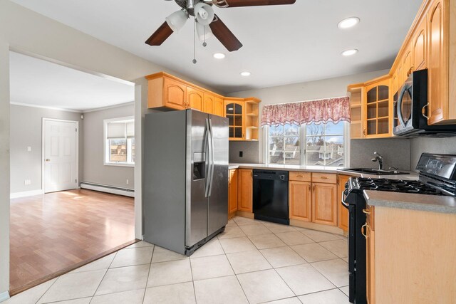 kitchen featuring a wealth of natural light, a baseboard radiator, a sink, and black appliances