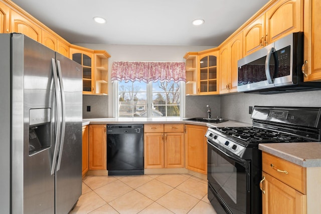 kitchen with tasteful backsplash, glass insert cabinets, black appliances, open shelves, and a sink